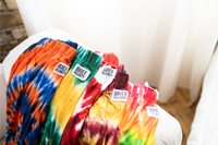 Thumbnail for Image of a group of lounge pants laid out on arm of couch