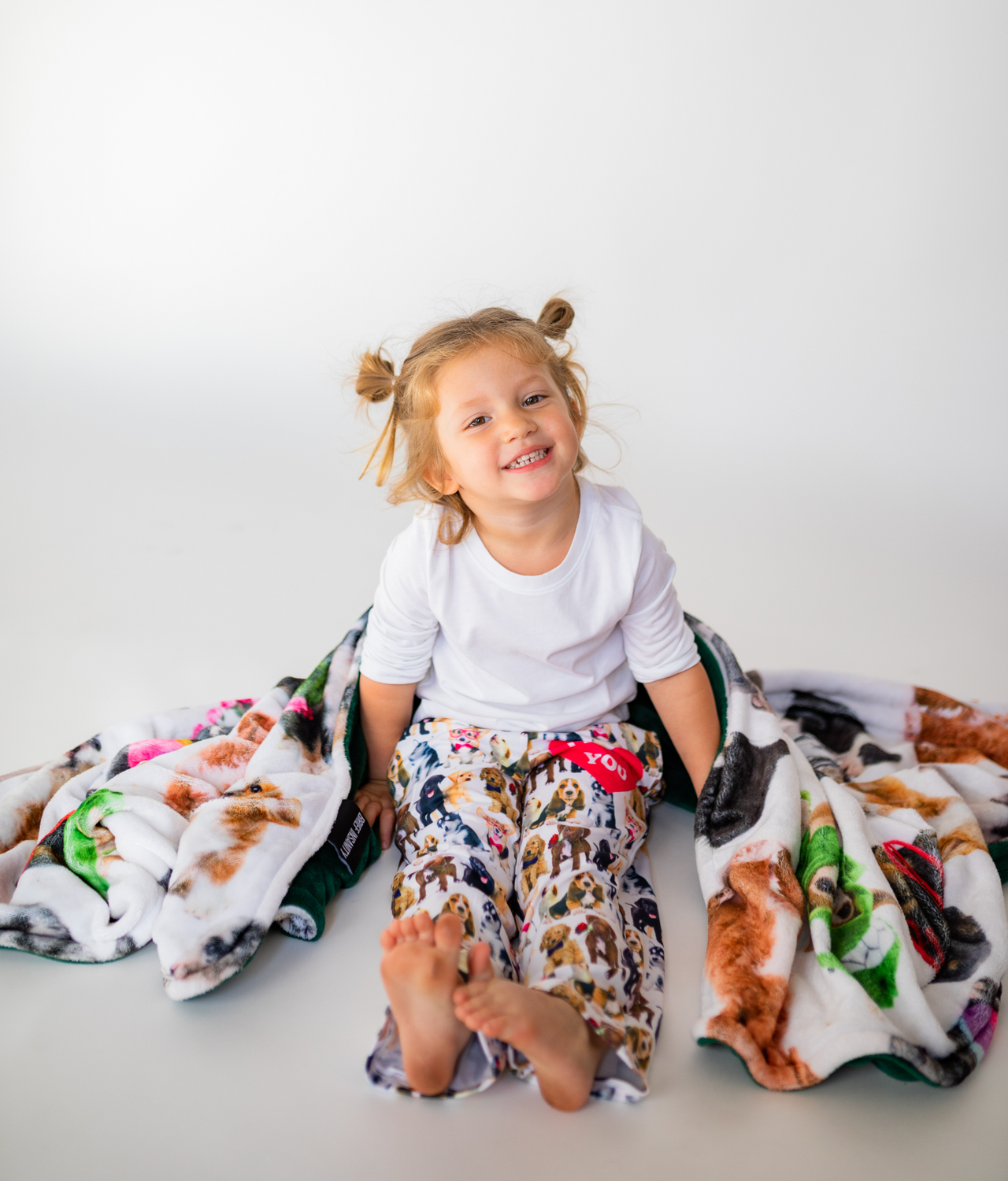 Toddler wearing Briefly Kids I Ruff You Pajama Lounge Pants wrapped in a cozy Life is Better with a Dog Throw Blanket