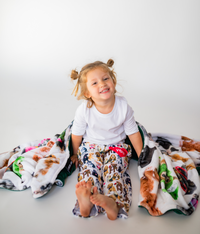 Thumbnail for Toddler wearing Briefly Kids I Ruff You Pajama Lounge Pants wrapped in a cozy Life is Better with a Dog Throw Blanket