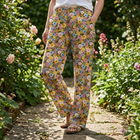 Thumbnail for Macro shot of Floral Tweety Lounge Pants highlighting the intricate floral print and Tweety Bird accents with a blurred garden background.