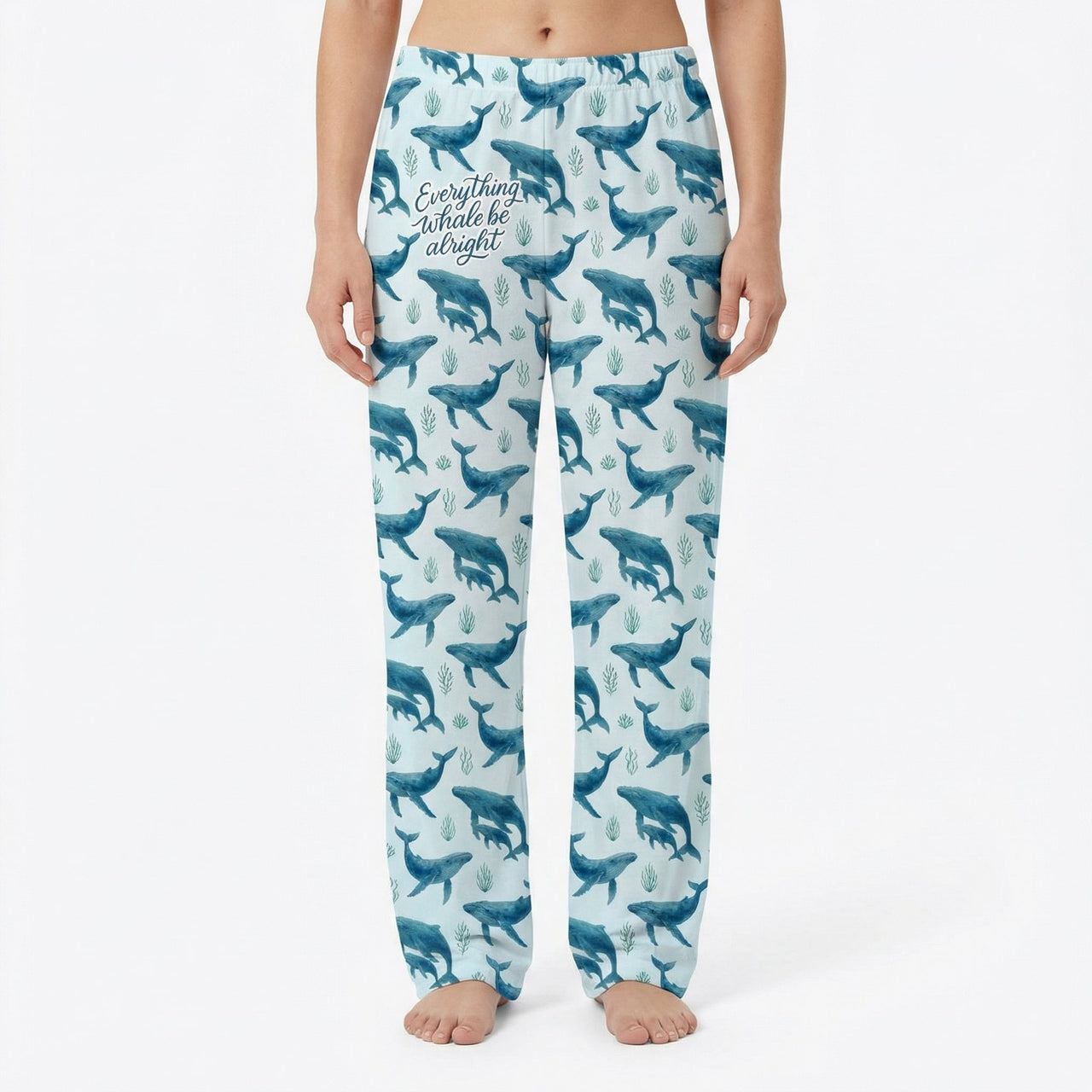 Model wearing Everything Whale Be Alright lounge pants with whale and seaweed print on a white background, centered and fully visible.