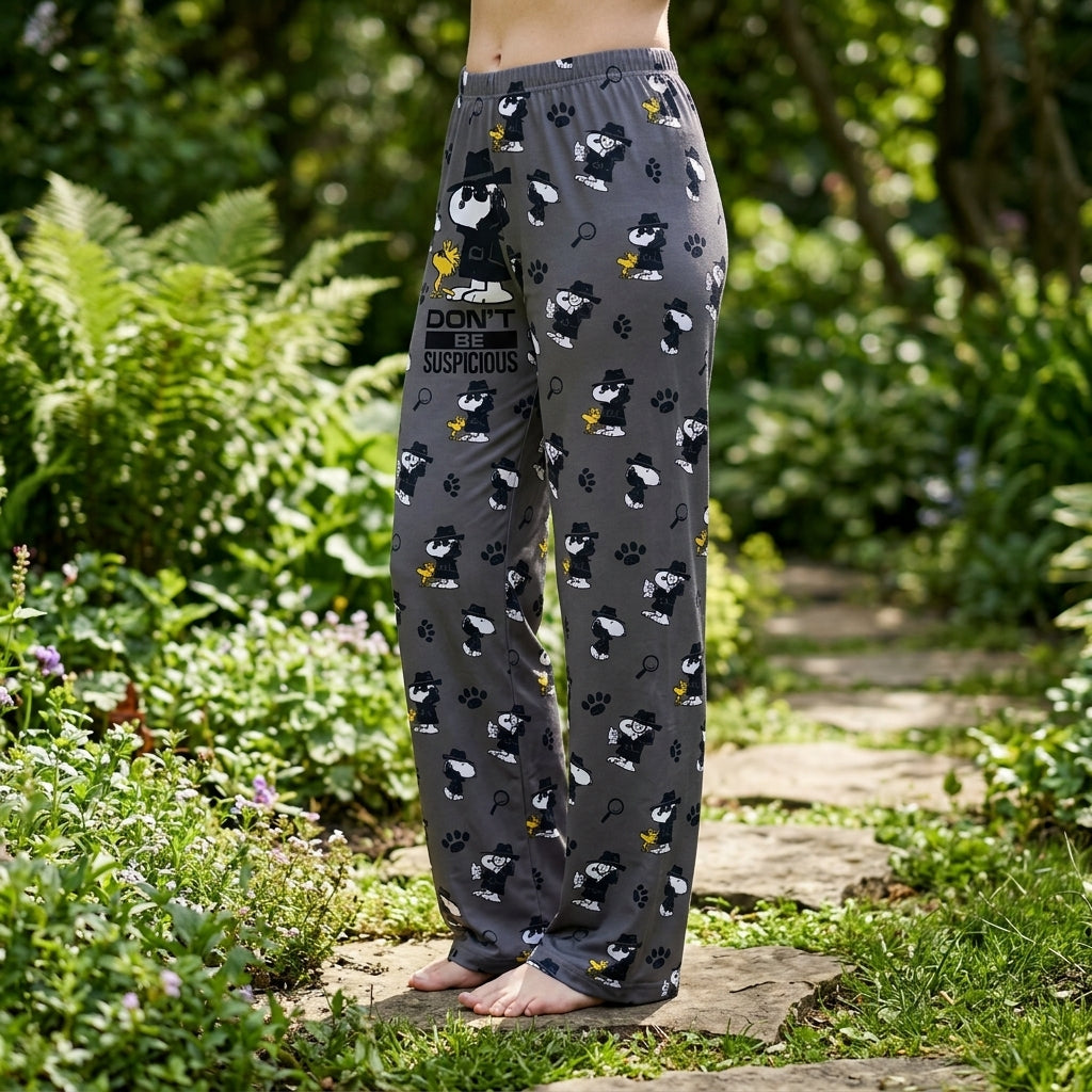Female model outdoors in garden wearing Detective Snoopy Lounge Pants, daylight highlighting playful print and fabric micro-texture.