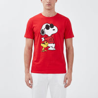 Thumbnail for Close-up of Snoopy Joe Cool sleep shirt for men, showcased on a model with white lounge pants in a bright studio setting, highlighting modern fashion style.