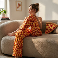 Thumbnail for Stylish model seated on sofa wearing Pepperoni Lounge Pants, emphasizing fabric texture, sheen, and food-themed decor with cinematic lighting.