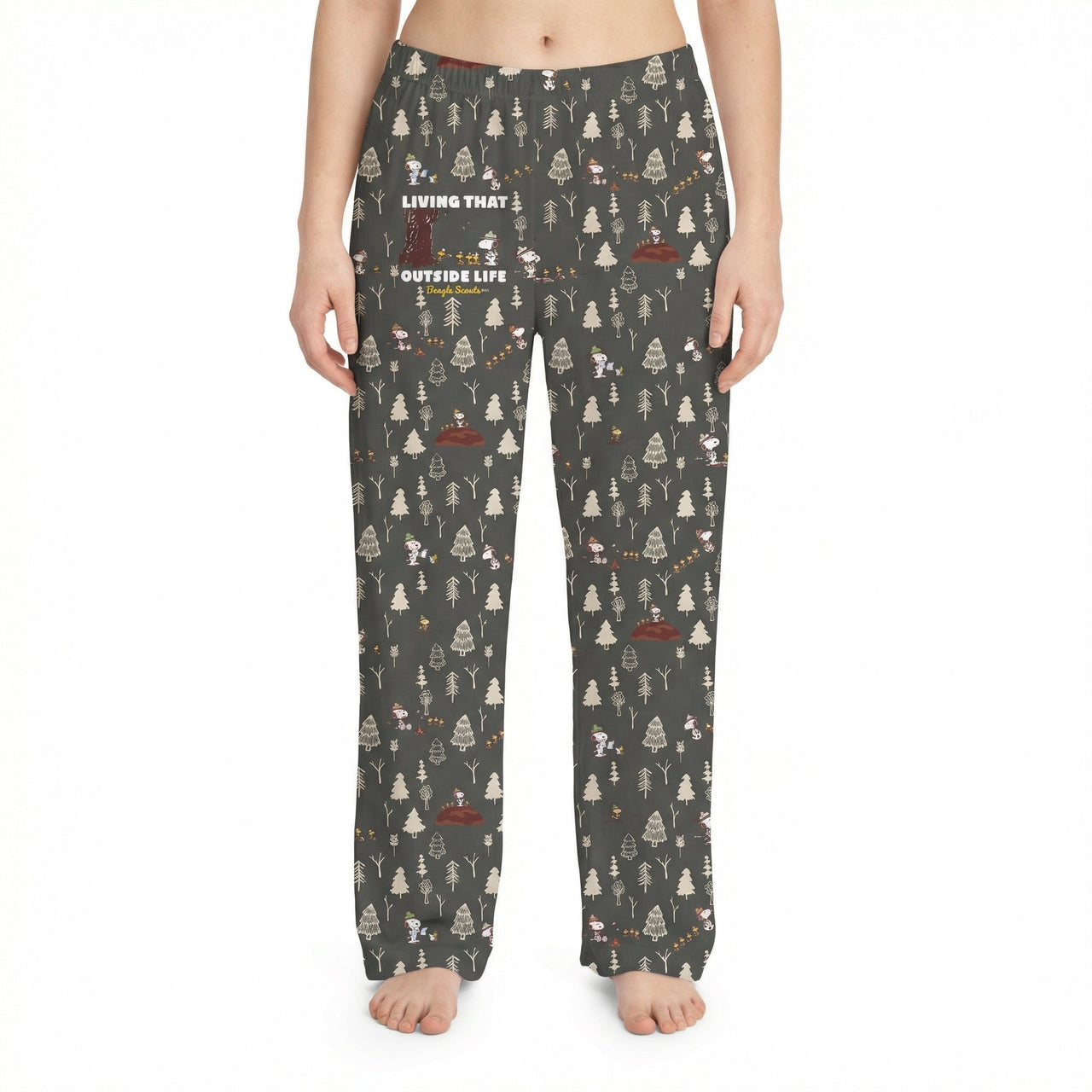 Studio shot of Snoopy Outside Life lounge pants on a female model against white background, emphasizing the woodland print and fabric texture.
