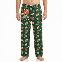 Thumbnail for Model wearing green football-themed lounge pants featuring Snoopy and game day graphics, cropped from waist to ankles against white background.